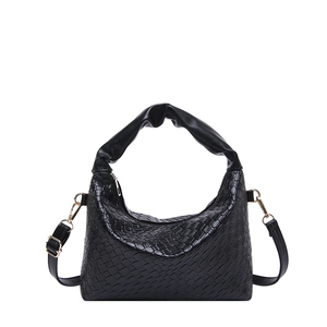Black woven texture shoulder bag with top handle and gold hardware in a minimalist style