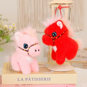 Detail of plush pony dolls in pink and red with shiny eyes and long fluffy fur texture