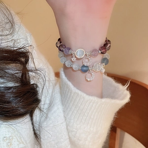 Beaded bracelet set with cat eye stones and moon star charms on a female wrist