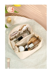Top view of beige large capacity makeup bag with multi-compartment interior for travel