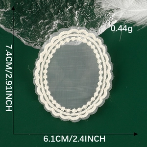 Detailed view of white oval lace patch with floral embroidery measuring 7.4cm by 6.1cm