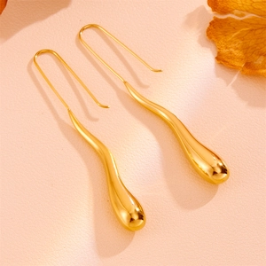 Close-up of polished gold teardrop earrings with a sleek minimalist streamlined design