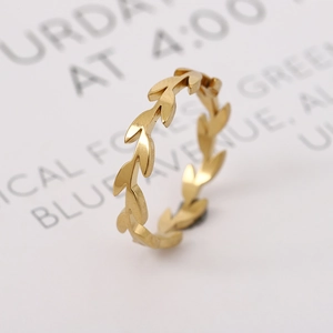 Golden 18k titanium steel leaf ring with polished finish on a white decorative card