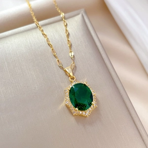 Macro shot of gold twist chain with emerald green oval pendant and white zircon halo