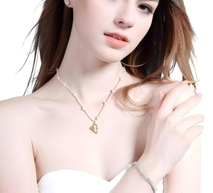 Detail showing elegant gold heart pendant and flower beaded necklace on female model
