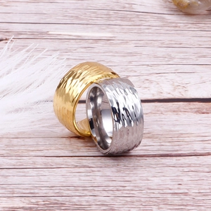 Detailed view of gold and silver stainless steel rings with irregular hammered textures
