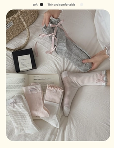 Dettaglio di calze stile ballerina con nastri di seta e pizzo in rosa e grigio