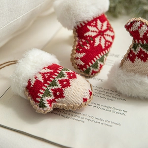 Christmas knit stocking and glove ornaments with white faux fur on a vintage book