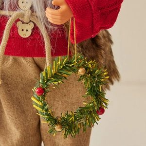 Standing Santa Claus doll in red sweater holding a miniature Christmas wreath ornament