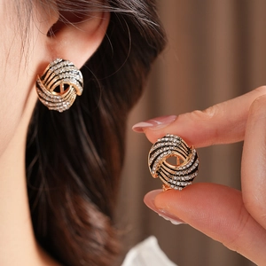 Gros plan détaillé des boucles d'oreilles vintage en or avec cristaux et émail noir