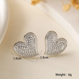 Macro shot of silver heart studs with pavé zircons showing 1.9cm size and 6g weight