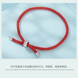 Close-up of red woven cord bracelet with s925 silver adjustable slider on blue background