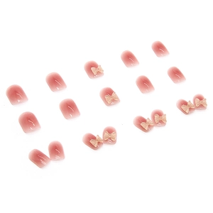 Pink gradient press-on nails set featuring 3D resin butterfly bows on white background