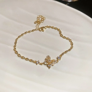Macro detail of 18k gold plated butterfly pendant necklace with shimmering cubic zirconia