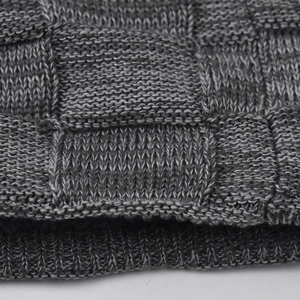Detailed close-up of thick grey knit beanie with plush fleece lining and checkered pattern