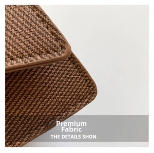 Macro du tissu tissé marron et des surpiqûres en cuir fin sur un mini sac à bandoulière