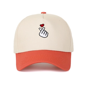 Close-up of heart finger gesture embroidery on beige and orange baseball cap