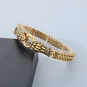 Macro shot of gold-plated snake head bracelet with vintage scales and texture