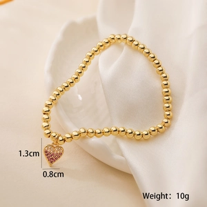 Detail showing pink heart pendant on gold beaded bracelet with 1.3cm size specs