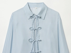Détail d'une chemise en popeline à rayures bleu clair avec trois nœuds papillon sur le devant