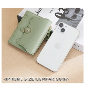 Compact light green wallet with quilted pattern and flower clasp shown next to iPhone