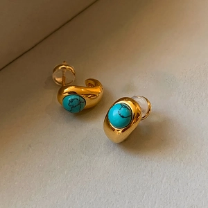 Close-up of 18k gold plated hoop earrings with round turquoise stones and glossy finish