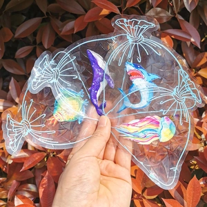 Close-up of clear sea animal pattern gift bag with shark and turtle held in natural light