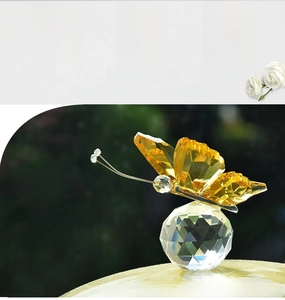 Detailed view of amber crystal butterfly ornament on a faceted clear glass base