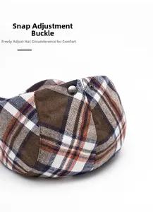 Close-up of the metal adjustment buckle on the plaid beret for a custom fit