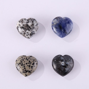 Detailed flat lay of four polished heart-shaped natural stones in varied colors on white background