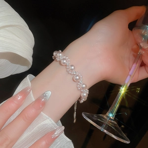 Detail of elegant pearl bracelet with diamonds worn on wrist during formal social event
