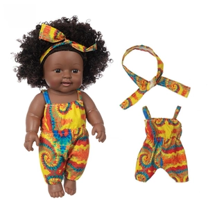 Detail of 12 inch African baby doll wearing yellow tie-dye romper and matching headband