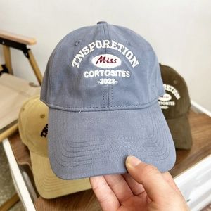 Close-up of white letter embroidery detail on retro cotton baseball cap fabric