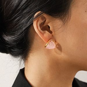 Pink resin triangle stud earrings with 18k gold plated stainless steel edges on ear
