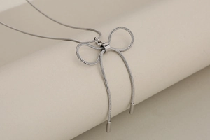 Detailed view of a silver bow pendant on a high-quality stainless steel snake bone chain
