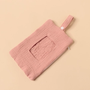 Detailed macro view of the dusty pink cotton crepe fabric texture and button handle