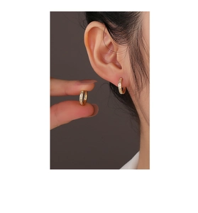 Close-up of gold plated silver hoop earrings with a square-cut white zircon stone