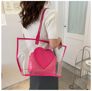 Detailed view of a transparent PVC tote bag with pink trim and heart-shaped inner pouch