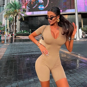 Outdoor shot of a beige short sleeve bodysuit with a deep V-neck on a female model