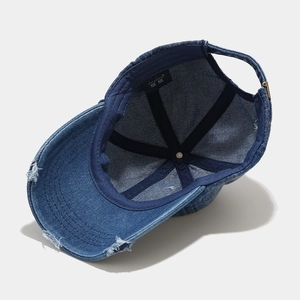 Deep blue washed denim baseball cap with distressed brim and internal details