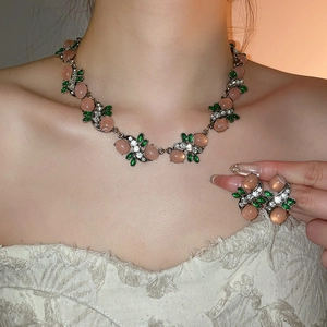 Baroque style jewelry set with pink and green stones shown on model for elegant look