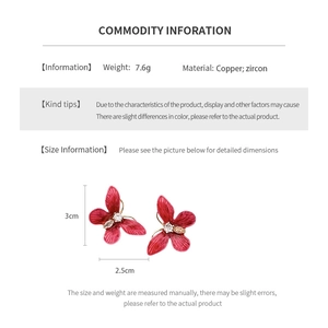 Vue détaillée des boucles d'oreilles papillon en zircon rouge avec dimensions et détails