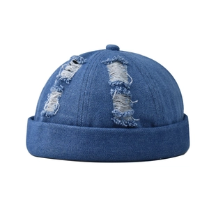 Detail of blue washed denim brimless docker hat featuring vintage distressed ripped texture