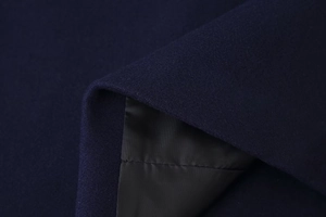 Detail-Makroansicht von dunkelblauem Wollmantelstoff mit hochwertigen schwarzen Innenfutter-Nähten