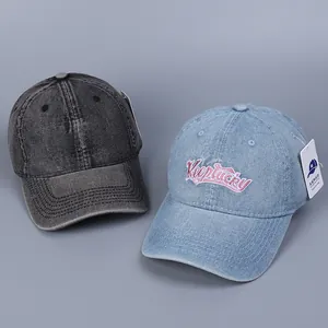 Detail of washed denim baseball caps with heart embroidery and Keepluckey lettering