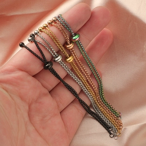 Adjustable stainless steel bolo bracelets in five colors on soft pink silk fabric