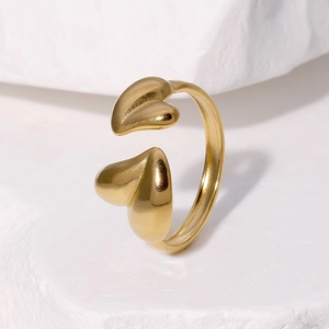 Minimalist gold heart-shaped open ring on white stone background with polished finish