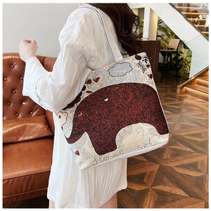 Detailed texture of ethnic canvas tote bag with red elephant and floral embroidery