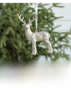 Nahaufnahme eines silbernen Glitzer-Rentier-Anhängers an einem Weihnachtsbaum