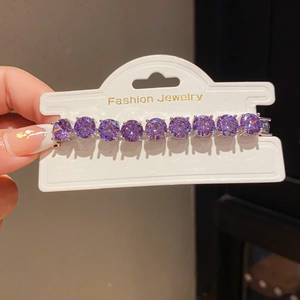 Close-up of luxury bracelet featuring round purple crystals and a polished silver setting